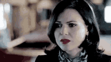 a close up of a woman 's face with red lipstick and earrings .