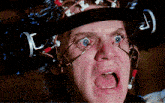 a close up of a man wearing a helmet with wires attached to it