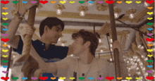 a couple of men are riding a merry go round with hearts around them
