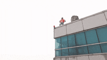 a man stands on the roof of a building