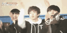 a group of young men are standing next to each other with their arms in the air and one has the letter d on his shirt