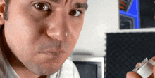 a man is making a funny face while holding a piece of metal