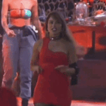 a woman in a red one shoulder dress is dancing on a stage