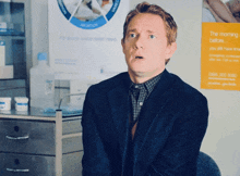 a man is sitting in front of a poster that says " the morning before "