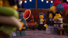a group of lego figures standing in front of balloons