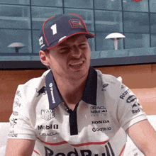 a man wearing a hat with the number 1 on it and a shirt that says honda