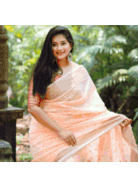 a woman is wearing a peach colored saree with a red blouse