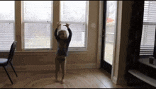 a little girl is dancing in a living room