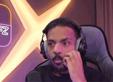a man wearing headphones is sitting in front of a microphone .