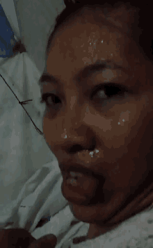 a close up of a woman 's face with her tongue out