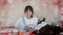 a woman sitting at a table with a dog wearing a shirt that says real on it