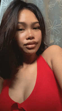 a woman in a red top is taking a picture of herself