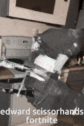 a person wearing black gloves is holding a pair of scissors in their hands