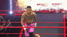 a man in a wrestling ring with a sign that says impact plus on it