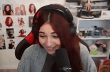 a woman wearing headphones is smiling in front of a microphone .
