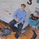 a man is sitting on a bed in front of a sign that says think safe
