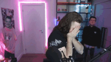 a man with a tattoo on his arm is covering his face with his hands