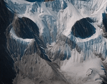 a mountain covered in snow and rocks that looks like a cat 's face