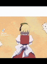 a girl in a red dress and white apron is standing next to a cat .