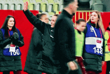 the number 148 is on the blue vest of a person