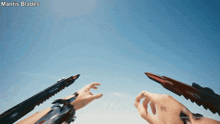 a person holding a mantis blades in their hand