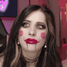a close up of a woman 's face with red lipstick and a choker