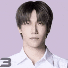 a close up of a young man wearing a white shirt and looking at the camera .