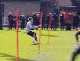 a soccer player is jumping over a fence on a field
