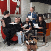 a group of people are sitting around a table with papers in their hands