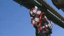 a man in a red and white robot costume holds a gun