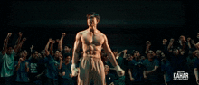 a man stands in front of a crowd with his fist in the air and the word kahar on the bottom