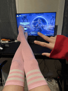 a person wearing pink knee high socks is playing a video game on a computer