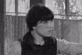 a black and white photo of a girl with pigtails and a ponytail .
