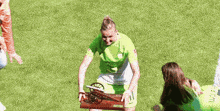 a female soccer player is holding a trophy on the field .