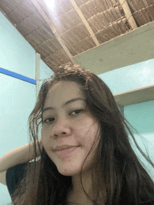 a woman with long hair looks at the camera and smiles