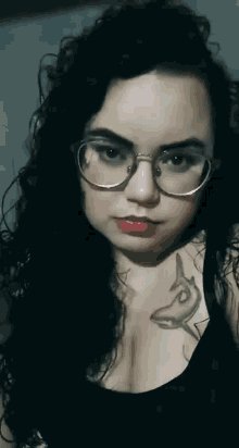 a woman with glasses and a tattoo of a shark on her chest