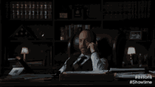a man with a beard is sitting in a chair in a dark room .