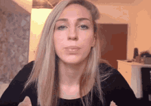 a woman blowing a kiss with her mouth open
