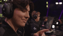a man wearing headphones giving a thumbs up sign