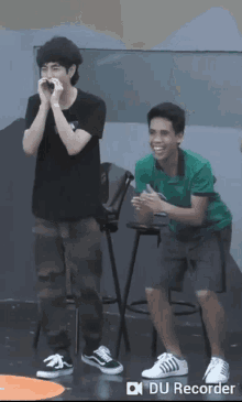 a man in a green shirt is standing next to another man
