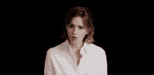 a woman wearing a white shirt making a funny face