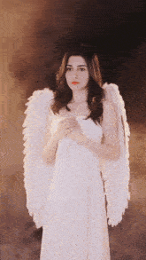 a woman in a white dress with white angel wings