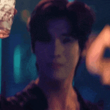 a blurry picture of a man holding a glass in his hand