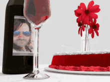 a bottle of wine with a picture of a man on the label next to a cake