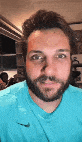 a man with a beard wearing a nike shirt