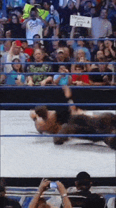a crowd of people watching a wrestling match with a sign that says " streamer becomes a ten "