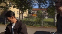 a man in a baseball cap is talking to another man in a park