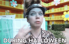 a woman wearing a visor and a leopard print shirt says " during halloween "