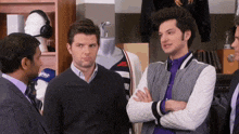 three men are standing in a store and one of them is wearing a jacket that says bomber on it