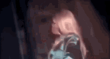 a close up of a woman 's face in a dark room with a blurred background .